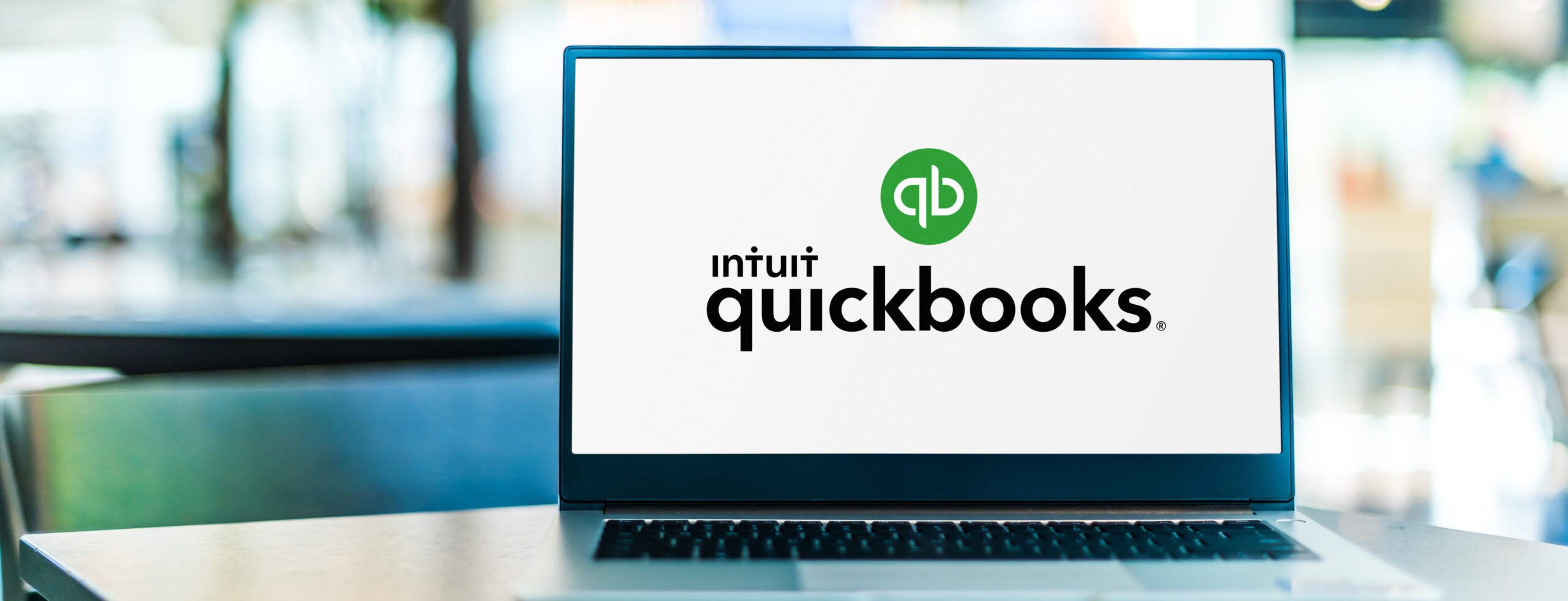 Laptop Sitting On Table With The Screen Open. The QuickBooks Logo Is On The Display. - Why Payroll Should Not Be Run In QuickBooks